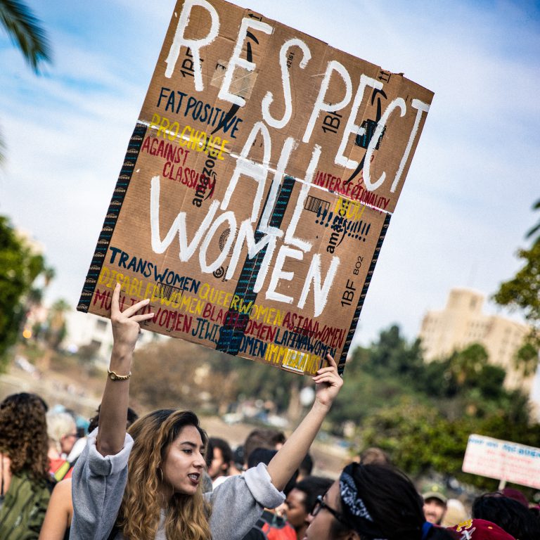 Young woman activist holding *Respect All Women* sign