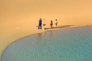 Desert beach with children and parent in traditional dress